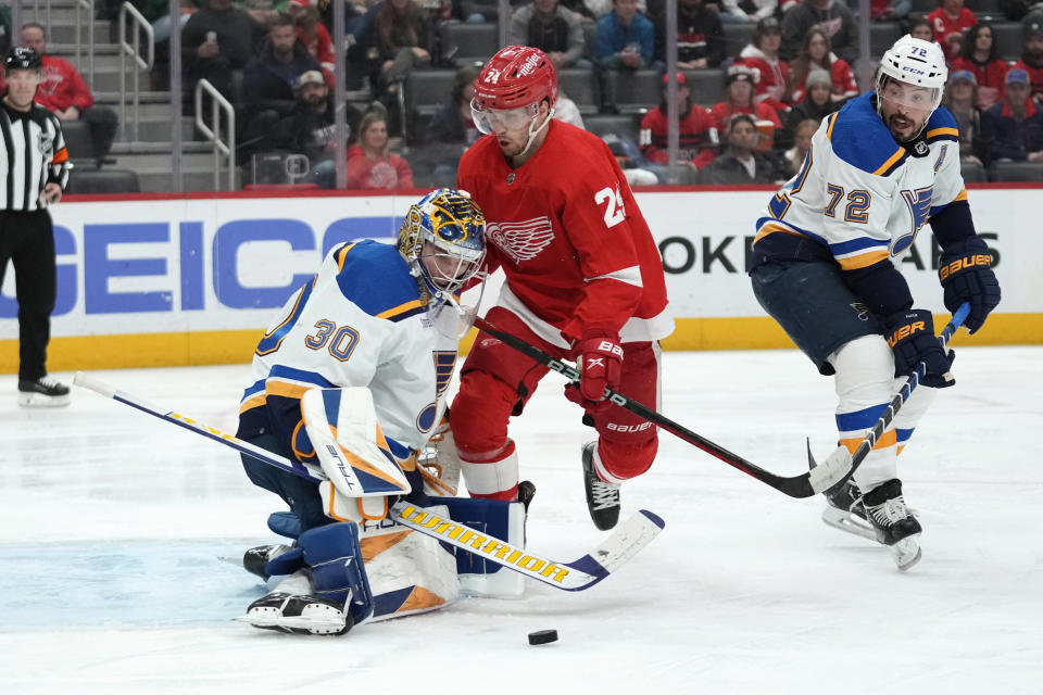 St. Louis Blues goaltender Joel Hofer (30) stops a shot as Detroit Red Wings center Pius Suter (24) watches for a rebound as Justin Faulk (72) defends in the second period of an NHL hockey game Thursday, March 23, 2023, in Detroit. (AP Photo/Paul Sancya)