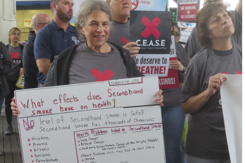 Elaine Rose, a frequent customer of Atlantic City N.J. casinos, holds a sign in support of a proposed smoking ban in the city's casinos during a rally there on Sept. 22, 2022. A gambler smokes while playing a slot machine at the Ocean Casino Resort in Atlantic City N.J. on Nov. 29, 2023. On Tuesday, Dec. 12, casino workers pushing for a smoking ban at the city's nine casinos publicized a letter from Shawn Fain, international president of the United Auto Workers union, calling on New Jersey lawmakers to ban smoking in the casinos. (AP Photo/Wayne Parry)