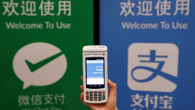 A woman demonstrates a high security digital unit built by Motion Pay, that allows customers to pay in Chinese yuan renminbi using Chinese online money payment services "WeChat Pay", and "Alipay", where payments get converted to Canadian dollars at point of sales locations in Canadian stores and businesses, in Toronto, Canada, May 24, 2017. REUTERS/Mark Blinch - RTX37HXO