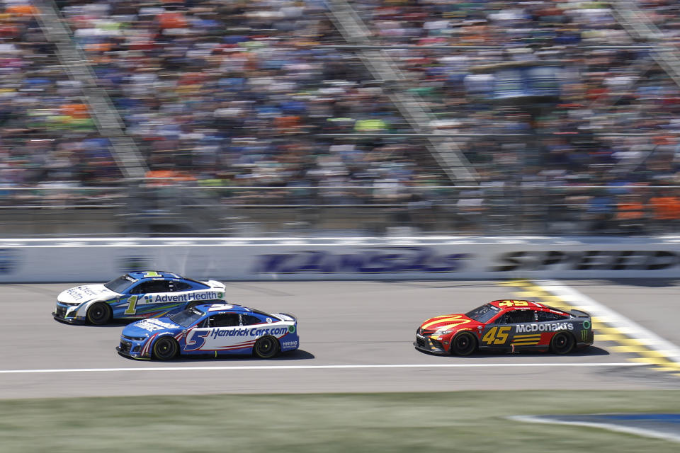 Ross Chastain (1) Kyle Larson (5) and Tyler Reddick (45) head down the front straightaway during a NASCAR Cup Series auto race at Kansas Speedway in Kansas City, Kan., Sunday, May 7, 2023. (AP Photo/Colin E. Braley)