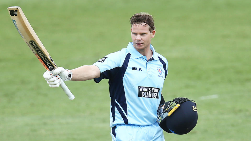 Steve Smith (pictured) raises his bat to celebrate his century against Victoria.