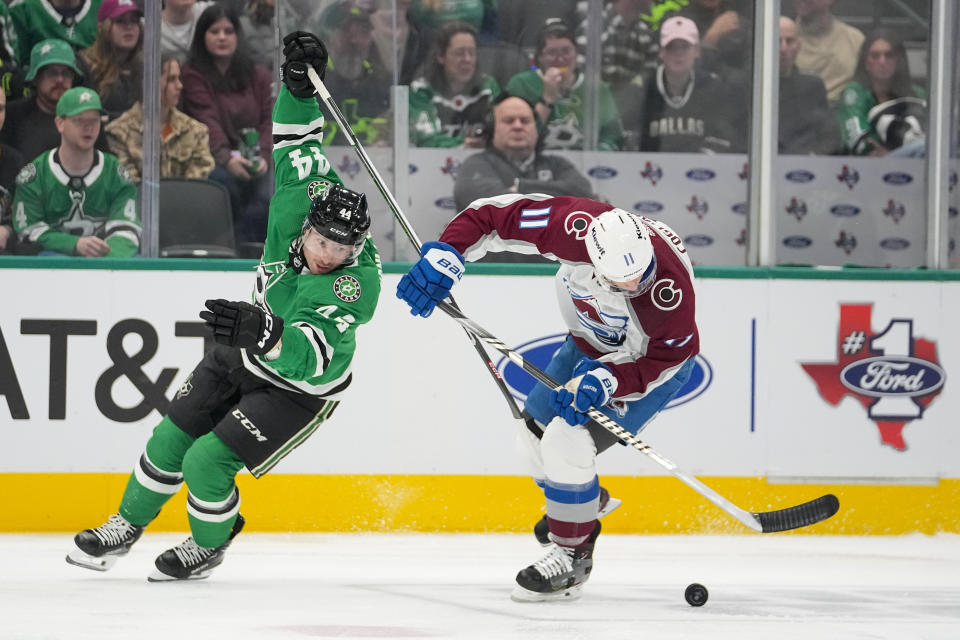 Dallas Stars defenseman Joel Hanley (44) and Colorado Avalanche center Andrew Cogliano (11) compete for the puck during the first period of an NHL hockey game, Thursday, Jan. 4, 2024 in Dallas. (AP Photo/Julio Cortez)