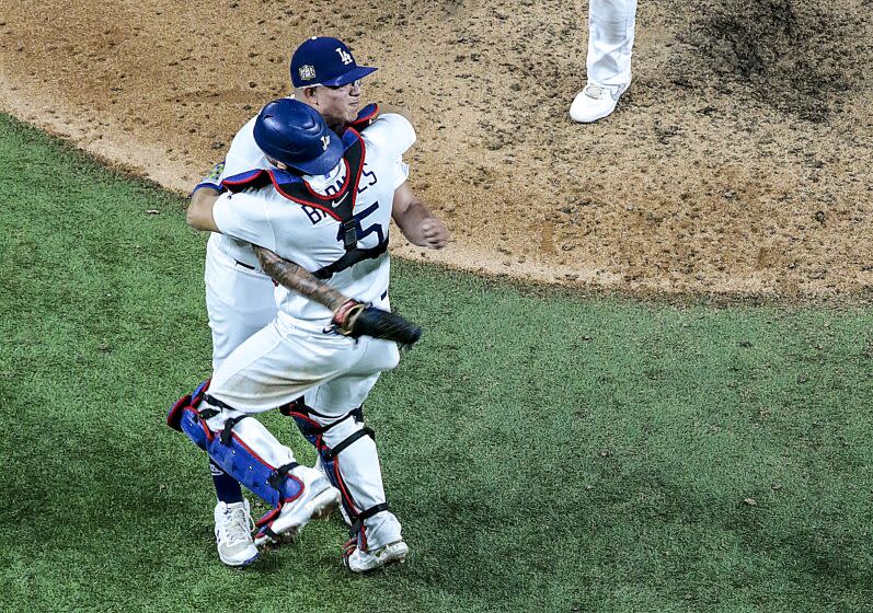 Austin Barnes and Julio Urias embrace after the final out in game six of the World Series at Globe Life Field.