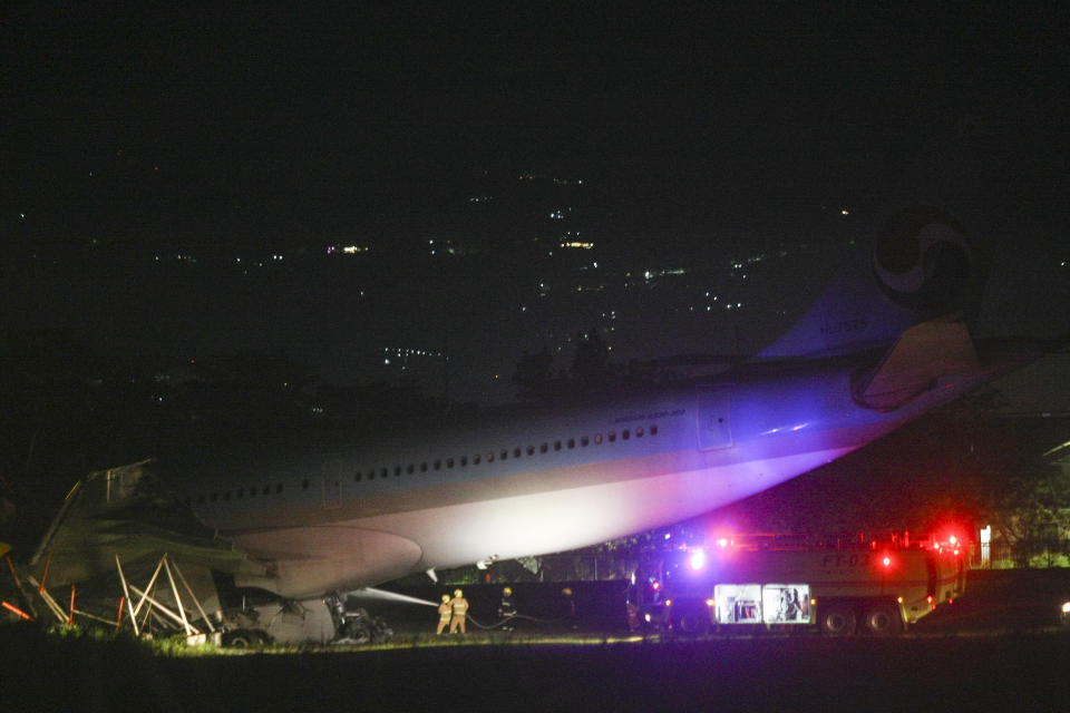 Firefighters train their hoses on a Korean Air Lines Co. plane after it overshot the runway at the Mactan-Cebu International Airport in Cebu, central Philippines, early Monday Oct. 24, 2022. A Korean Air Lines Co. plane carrying 173 passengers and crew members overshot a runway while landing in bad weather in the central Philippines late Sunday and authorities said all those on board were safe. The airport is temporarily closed due to the stalled aircraft. (AP Photo/Juan Carlo De Vela)