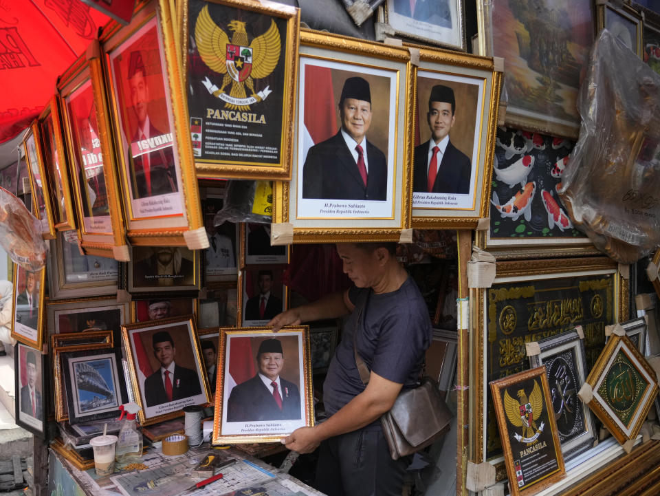 A vendor holds a portrait of Indonesian President-elect and Defense Minister Prabowo Subianto at a market in Jakarta, Indonesia, Wednesday, April 24, 2024. Indonesia's electoral commission formally declared Subianto as the elected president in a ceremony on Wednesday after the country's highest court rejected appeals lodged by two losing presidential candidates who are challenging his landslide victory. (AP Photo/Achmad Ibrahim)