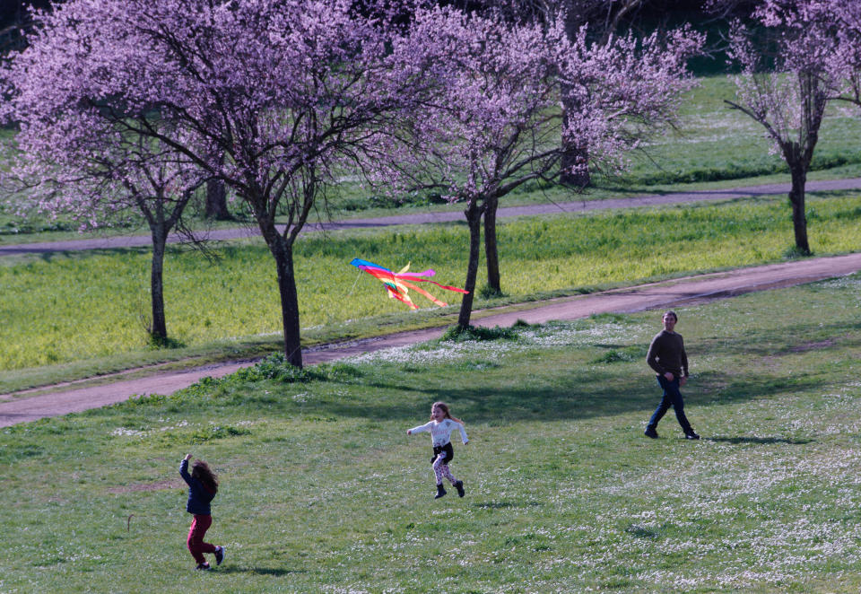 FILE - In this March 7, 2020, file photo, people enjoy the good weather in a park in downtown Rome. As outbreaks of the new virus that first emerged in China continue to spread in countries, particularly those experiencing winter, one of the biggest unanswered questions is how COVID-19 will behave in warmer weather. (AP Photo/Domenico Stinellis, File)