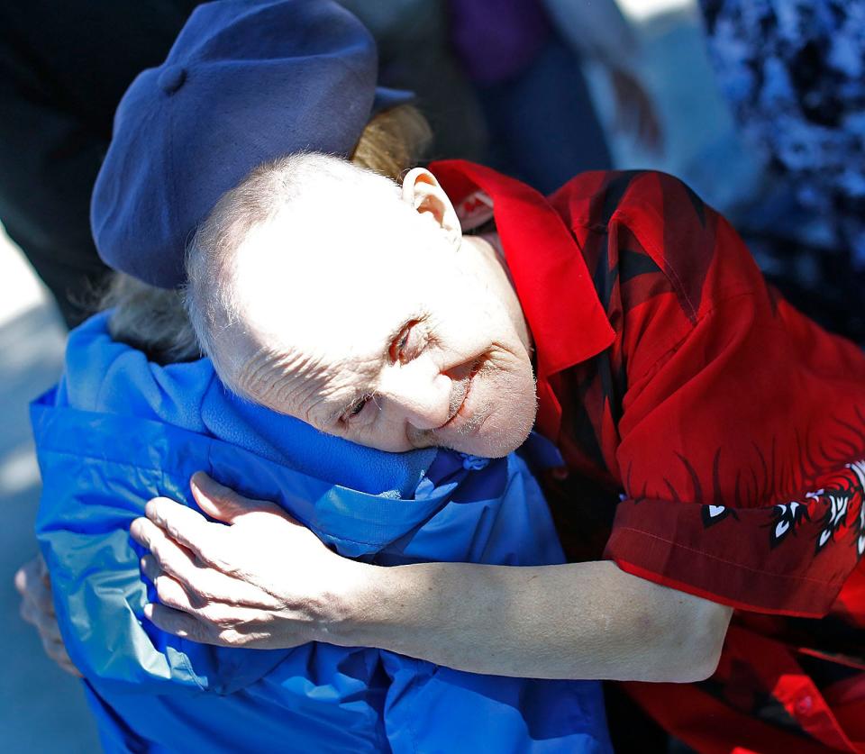 Friends of Stevie Abbot, 71, of Quincy, gather with him in front of the First Parish Church. As they get ready to leave, Stevie gives a goodbye hug to church member Sharon Gamache. Thursday, Sept. 29, 2022.