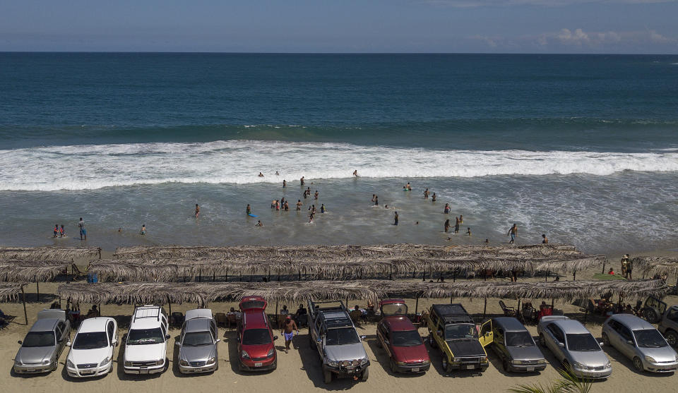 Una fila de carros están estacionados frente la playa Los Ángeles después de su reciente reapertura después de una cuarentena para enfrentar la pandemia del nuevo coronavirus en La Guaira, Venezuela, el viernes 23 de octubre de 2020. (AP Foto/Matias Delacroix)