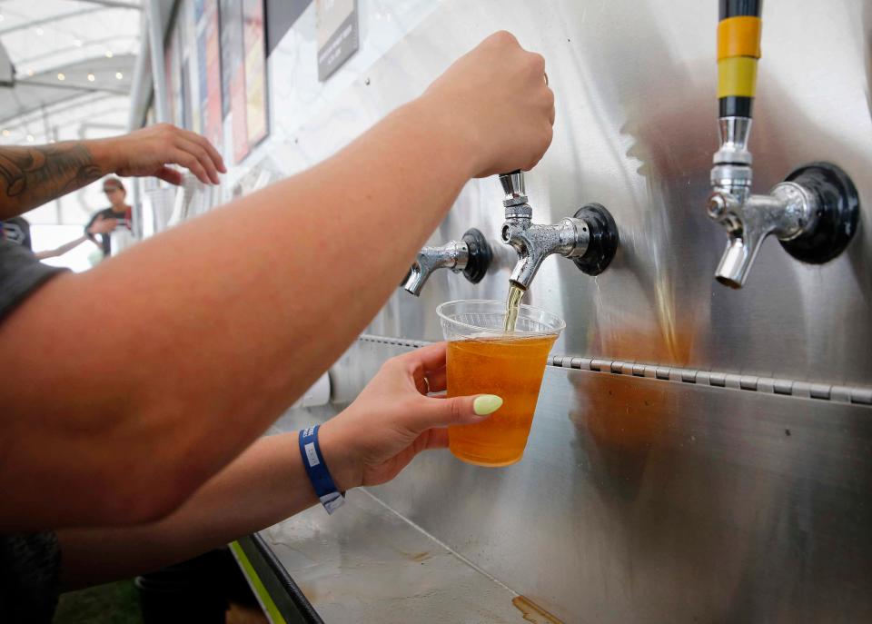 Sam Fitzgerald of Des Moines pours an Iowa-brewed beer at the Iowa Craft Beer Tent at the Iowa State Fair in Des Moines in 2021.