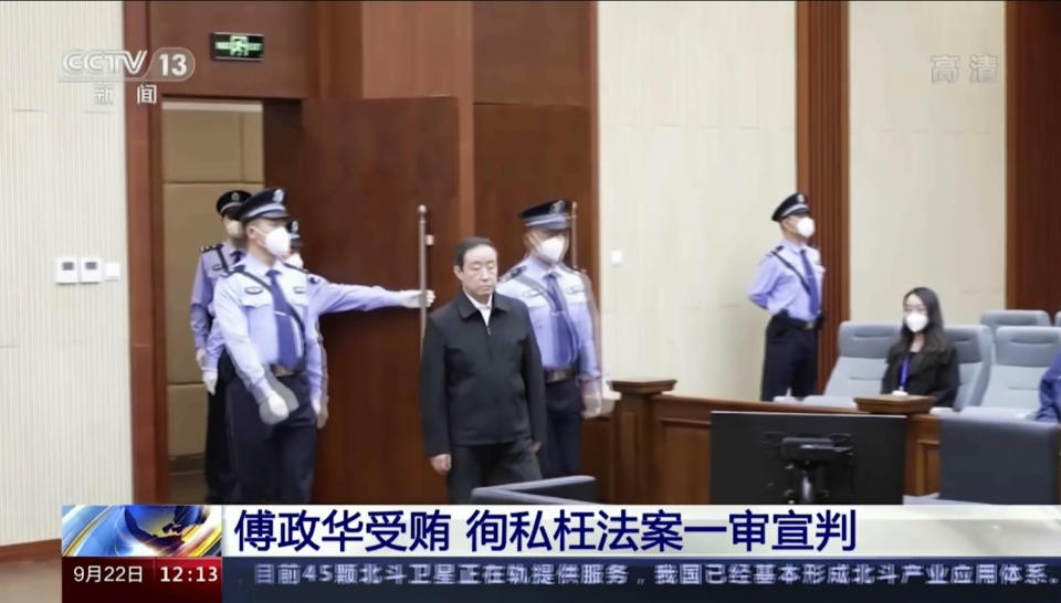 In this image taken from video footage run by China's CCTV, former Chinese justice minister Fu Zhenghua is escorted by court police as he attends a court session for his verdict announcement in Changchun, northeastern China's Jilin province on Thursday, Sept. 22, 2022. The former Chinese justice minister was sentenced to death with a two-year reprieve on charges of taking bribes and helping criminals including his brother hide illegal activity, state TV reported Thursday. (CCTV via AP)