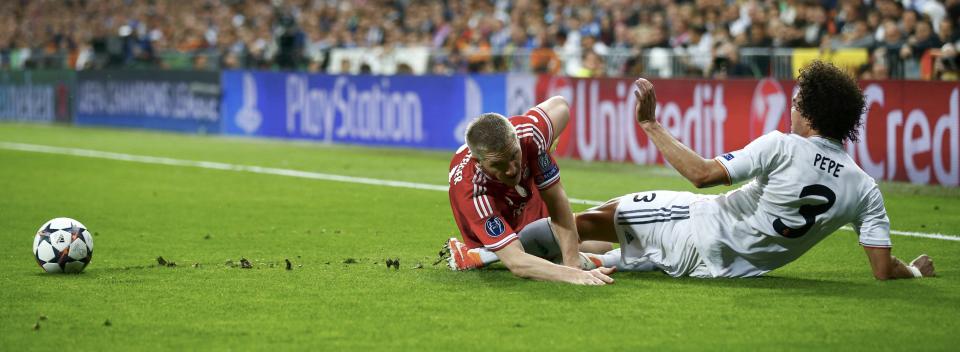 Bayern Munich's Schweinsteiger falls over Real Madrid's Pepe during their Champions League semi-final first leg soccer match at Santiago Bernabeu stadium in Madrid