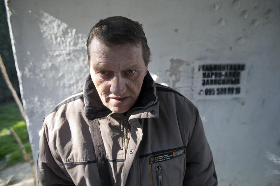 In this photo taken Tuesday, April 1, 2014, Viktor Levchenko, 36, a patient of treatment for drug addiction, poses at a bus stop with an advert reading "Rehabilitation of drug and alcohol addicts" in Sevastopol, Crimea. Across the Black Sea peninsula, some 800 heroin addicts and other needle-drug users take part in methadone programs, seen as an important part of efforts to curb HIV infections by taking the patients away from hypodermic needles that can spread the AIDS-causing virus. After Russia's annexation of Crimea methadone was banned. The ban could undermine years of efforts to reduce the spread of AIDS in Crimea. (AP Photo/Pavel Golovkin)