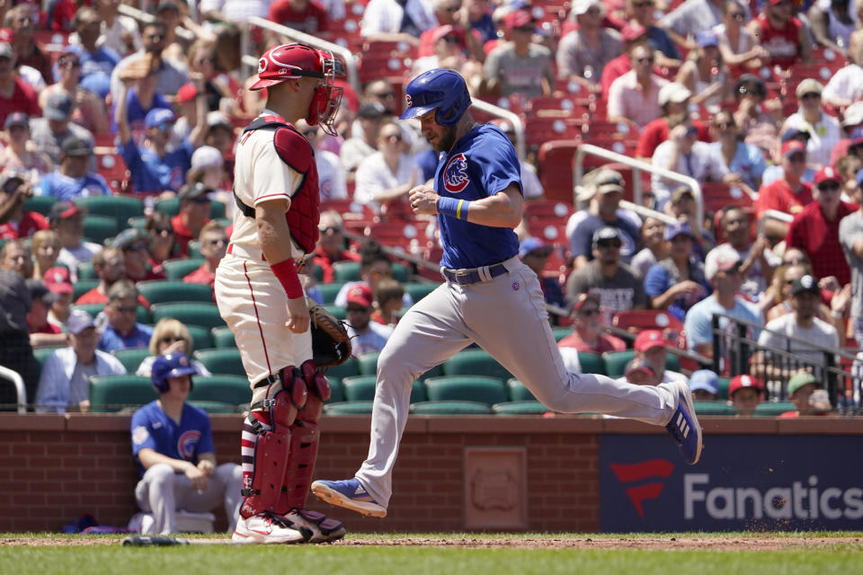 Chicago Cubs' Patrick Wisdom, right, scores past St. Louis Cardinals catcher Andrew Knizner during the fifth inning of a baseball game Saturday, June 25, 2022, in St. Louis. (AP Photo/Jeff Roberson)