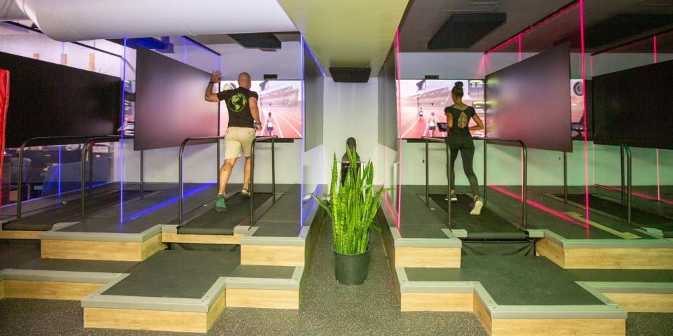 Two people running on treadmills at Roam149