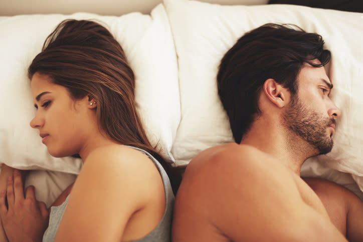 Couple facing away from each other in bed