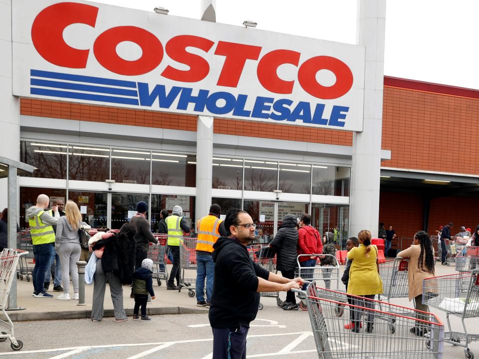 FILE PHOTO: Customers queue to enter a Costco Wholesalers in Chingford, Britain March 15, 2020. REUTERS/John Sibley