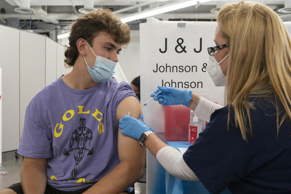 Bradley Sharp, of Saratoga, N.Y., gets the Johnson & Johnson vaccine from registered nurse Stephanie Wagner, Friday, July 30, 2021 in New York. Sharp needs the vaccination because it is required by his college. Amid increasing concern over the spread of the Delta variant, New York City announced on Wednesday that anyone can receive $100 if they get the first dose of the COVID-19 vaccine at any city-run vaccination clinic. (AP Photo/Mark Lennihan)