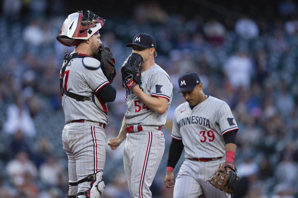 Minnesota Twins starting pitcher Sonny Gray, center, meets at the mound with third baseman Donovan Solano, right, and catcher Ryan Jeffers, left, during the fifth inning of a baseball game against the Seattle Mariners, Monday, July 17, 2023, in Seattle. (AP Photo/Stephen Brashear)