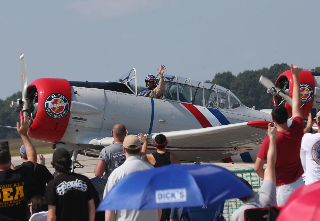 A Warbird Thunder plan pilot waves to the crowd as thousands of spectators gather for the Thunder Over New Hampshire Air Show at Pease Air National Guard Base in Portsmouth Saturday, Sept. 9, 2023.