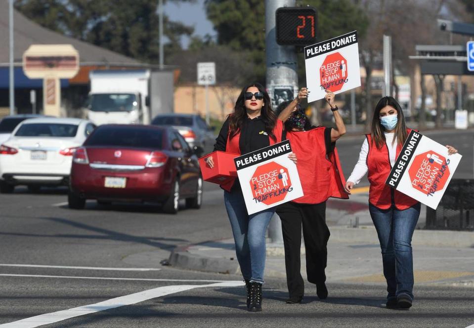 Anti-human trafficking advocates, from left, Jackie Cardona, Bernadette Agonza and Jennifer Duarte, cross Shaw Avenue at Blackstone during a rally to kick off the 5th Annual Pledge to Stop Trafficking event (PTST), Tuesday, Jan 18, 2022. as local leaders and anti-human trafficking organizations from Fresno, Clovis and Madera counties kicked off the 5th Annual Pledge to Stop Trafficking event (PTST), Tuesday, Jan 18, 2022. Human trafficking is the number two criminal enterprise, not only globally, but locally in the central valley, according to Debra Rush, Founder and CEO of Breaking the Chains, a non-profit organization that works with local, state, and federal law-enforcement agencies to help lives impacted by human trafficking.