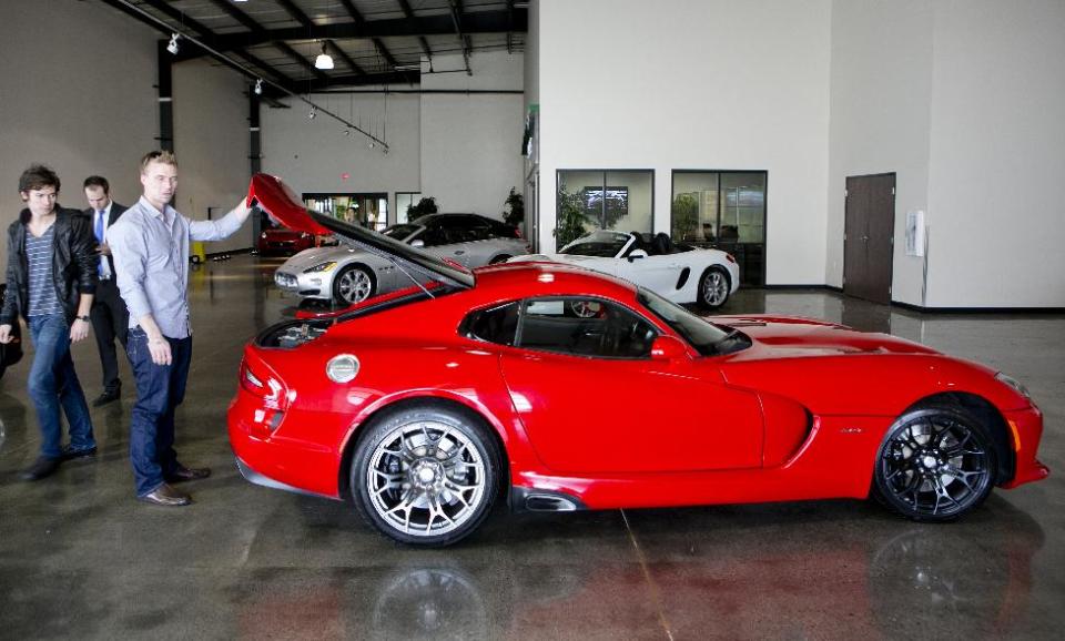 In this Wednesday, March, 26, 2014 photo, Michael Clark, 22, left, and Douglas Sawyer, 23, right, both from Chicago rent a 2013 Dodge Viper at the Enterprise Exotic Car Collection showroom near Los Angeles International Airport. (AP Photo/Damian Dovarganes)