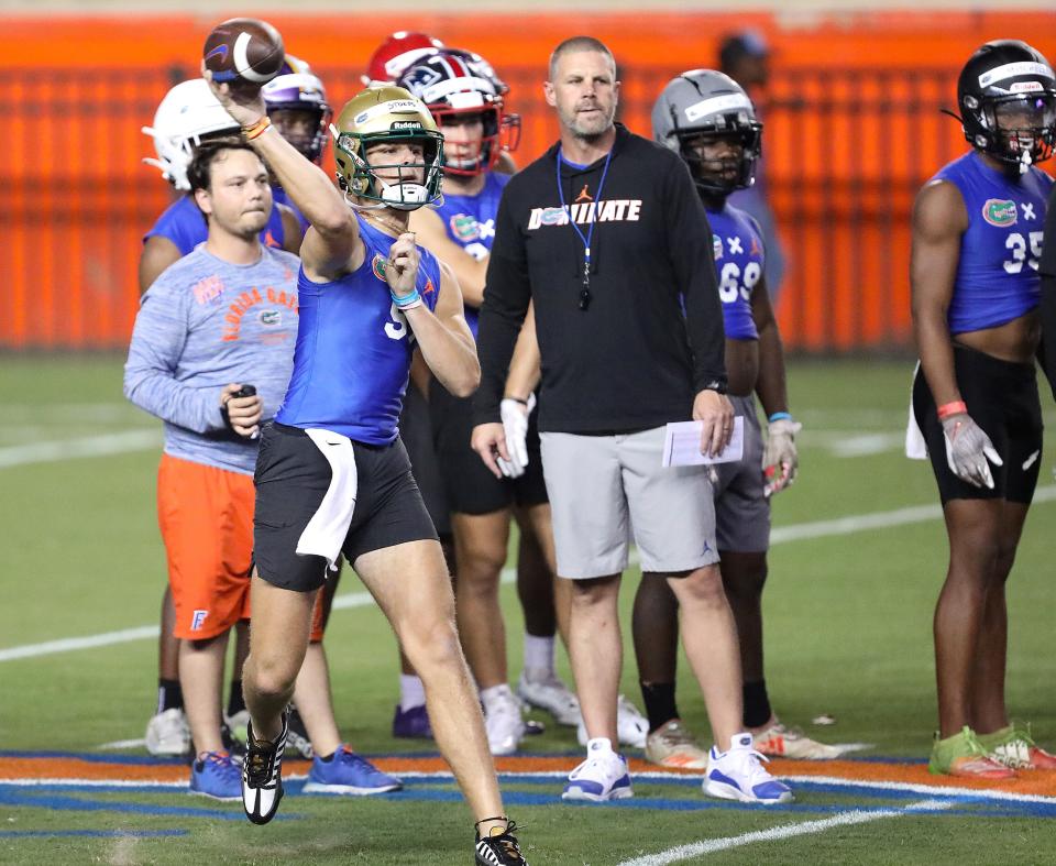 Florida Gators head coach Bill Napier, right, watches as quarterback commit Marcus Stokes throws during a drill at the annual football showcase at the University of Florida called Friday Night Lights, at Ben Hill Griffin Stadium, in Gainesville FL. July 29, 2022.