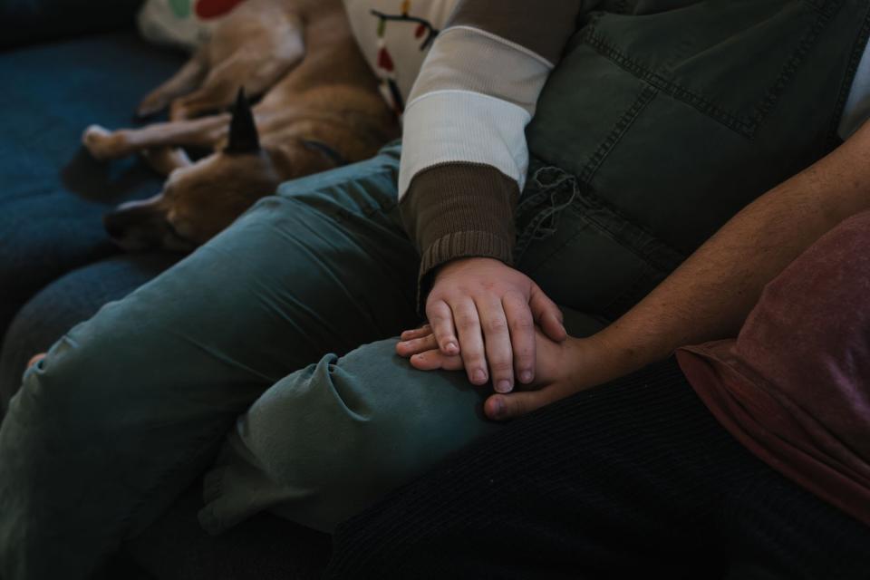 Guido hold his partner’s hand at their home in Wisconsin.