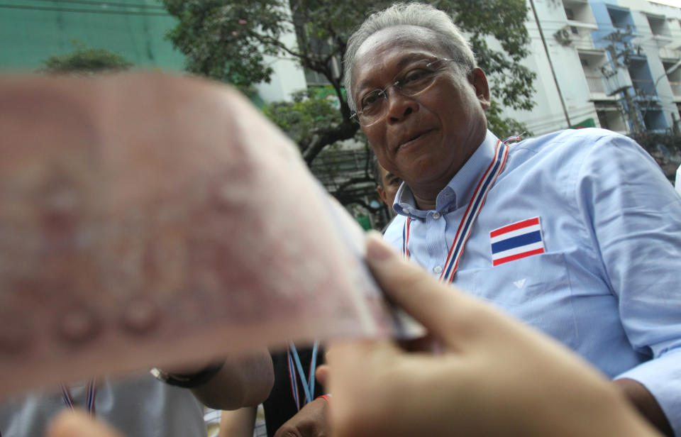 Anti-government protest leader Suthep Thaugsuban collects donation during a march through streets in Bangkok, Thailand, Monday, Feb. 10, 2014. They want caretaker Prime Minister Yingluck Shinawatra to step down to make way for an interim appointed government to implement what they say are necessary reforms to fight corruption. They've been protesting since November and have battled police on several occasions. (AP Photo/Sakchai Lalit)