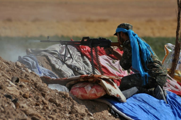 A member of the Kurdish People's Protection Units (YPG) fires towards Islamic State group jihadists on the southern outskirts of the Syrian city of Hasakeh on July 20, 2015