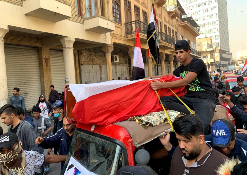 Mourners and protesters escort the flag-draped coffin of Munir Ali, whose family said was killed in anti-government demonstrations, during his funeral in Baghdad, Iraq, Sunday, Nov. 24, 2019. (AP Photo/Ali Abdul Hassan)