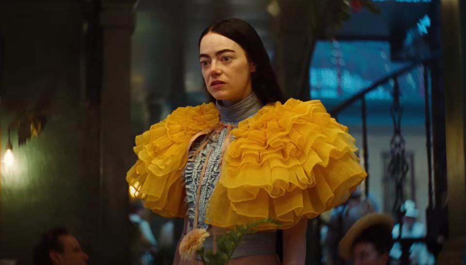Emma Stone in an elaborate yellow ruffled outfit