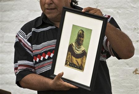 Seminole Tribe member and historian Willie Johns holds up a photograph of Polly Parker during a visit to Egmont Key State Park as part of a historic journey to retrace the "Voyage of Tears" in Egmont Key, Florida, December 1, 2013. REUTERS/Steve Nesius