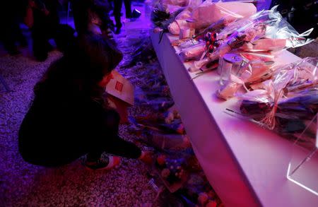 A woman leaves flowers at a vigil after a moment of silence to pay tribute to the victims of Paris attacks at the official residence for the French ambassador to Japan in Tokyo, Japan, November 15, 2015. REUTERS/Yuya Shino