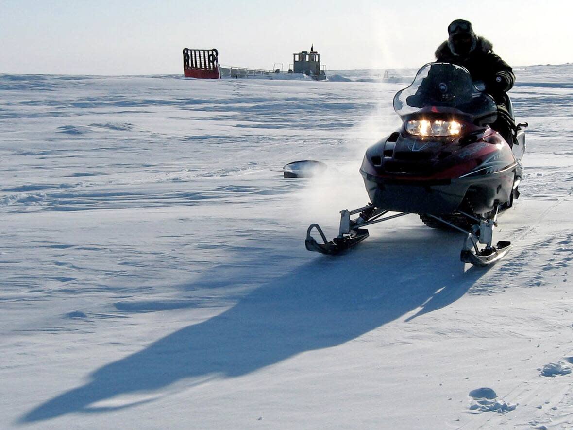 A Canadian part-time military volunteer drives over the frozen sea past an abandoned landing craft off Cornwallis Island, Nunavut on April 9, 2006. (David Ljunggren/Reuters - image credit)