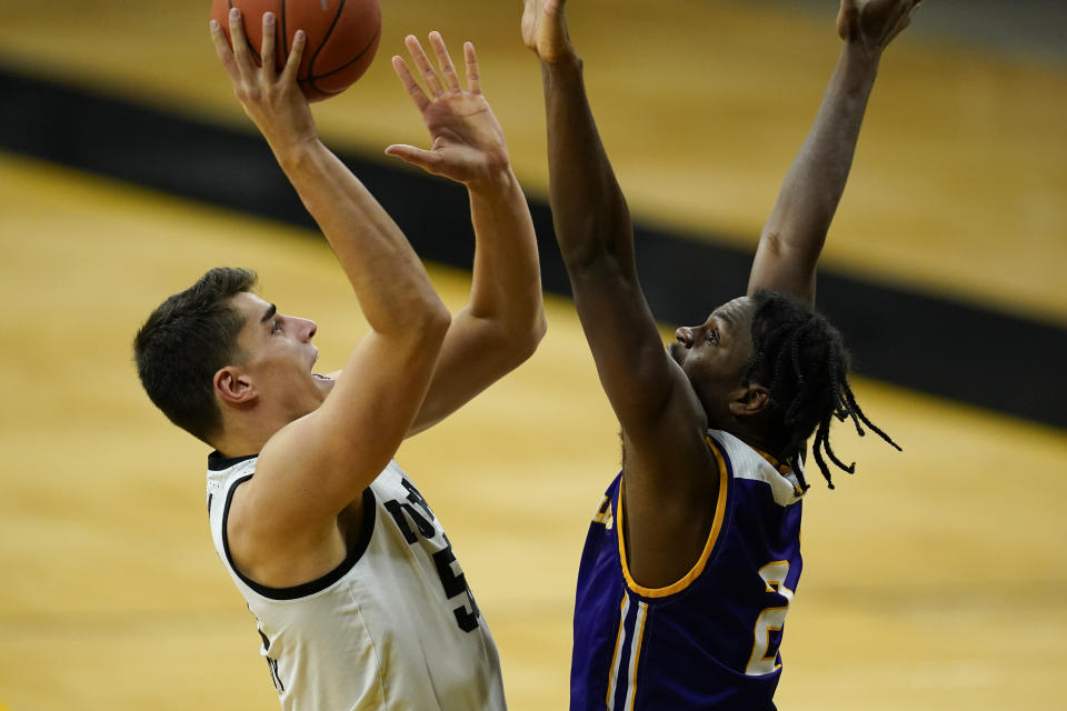 Iowa center Luka Garza shoots over Western Illinois forward Tamell Pearson, right, during the first half of an NCAA college basketball game, Thursday, Dec. 3, 2020, in Iowa City, Iowa. (AP Photo/Charlie Neibergall)