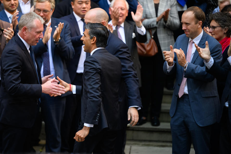 Matt Hancock (R) looks on during the arrival of Rishi Sunak (C) at Conservative Party Headquarters on 24, October in London, England. Rishi Sunak was appointed as Conservative leader and the UK's next Prime Minister after he was the only candidate to garner 100-plus votes from Conservative MPs in the contest for the top job. (Photo by Leon Neal/Getty Images)