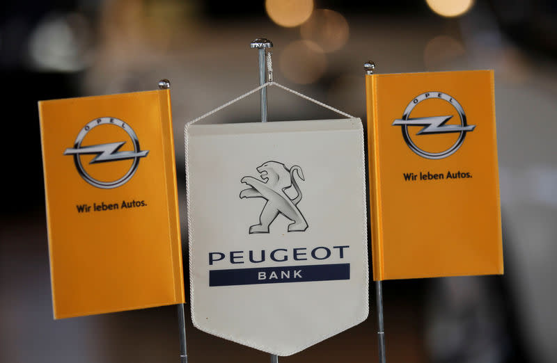 FILE PHOTO: The logo of German General Motors daughter Opel and the bank of French car maker Peugeot are seen at a Opel and Peugeot dealership in Leverkusen near Cologne October 22, 2012. REUTERS/Wolfgang Rattay/File Photo