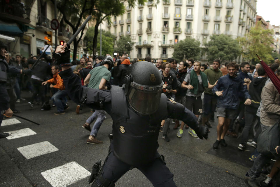 <p>Spanish riot police swings a club against would-be voters near a school assigned to be a polling station by the Catalan government in Barcelona, Spain, Oct. 1, 2017. Spanish riot police have forcefully removed a few hundred would-be voters from several polling stations in Barcelona. (Photo: Manu Fernandez/AP) </p>