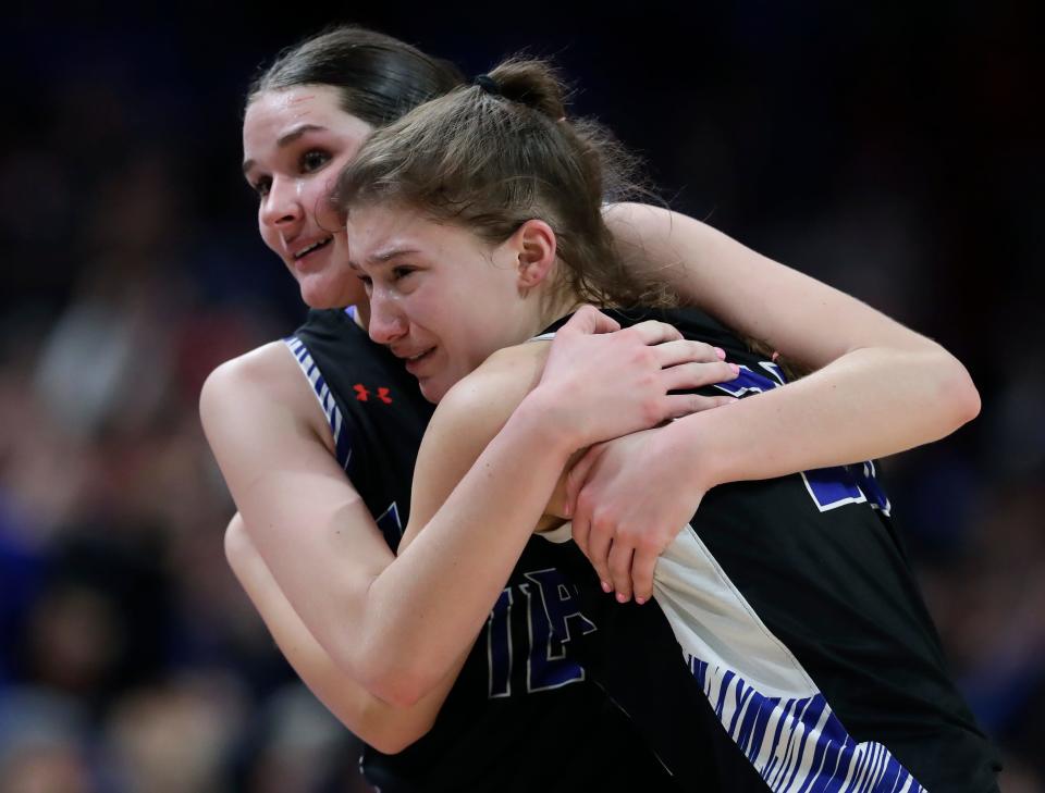 Lena's Eva Brooks, left, and Madi Thomson embrace after a 57-54 overtime loss against Albany/Monticello in the WIAA Division 5 state championship game Saturday at the Resch Center in Ashwaubenon.