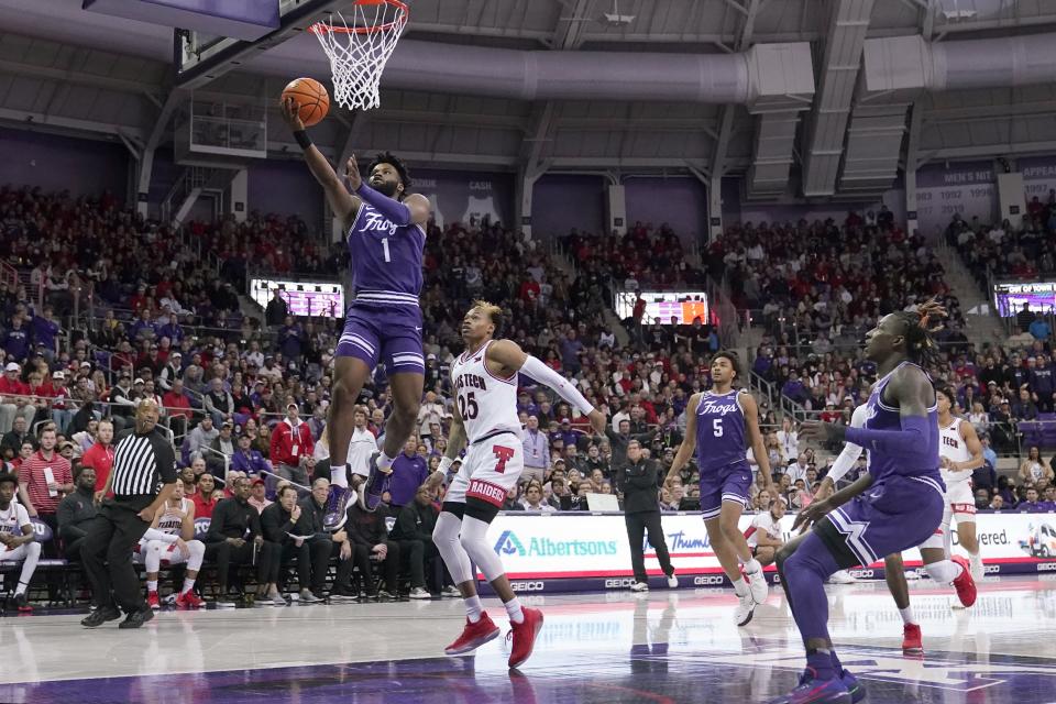 TCU guard Mike Miles (1) leaps to the basket for a shot after getting past Texas Tech guard Adonis Arms (25) in the first half of an NCAA college basketball game in Fort Worth, Texas, Saturday, Feb. 26, 2022. (AP Photo/Tony Gutierrez)