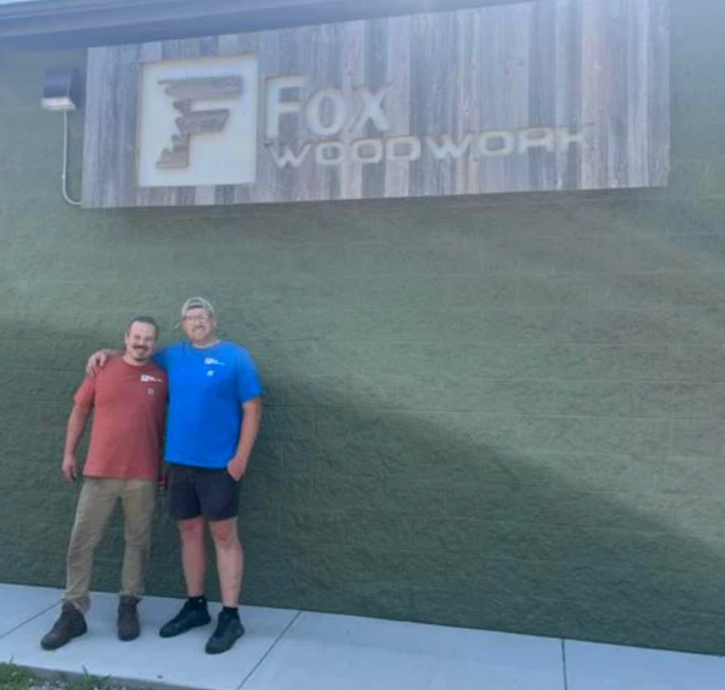 Adam Fox and Taylor Darling pose in front of Fox Woodwork in Ferrysburg.