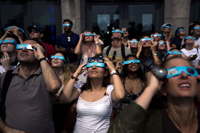 <p>Drew Angerer/Getty</p> People watching a solar eclipse in New York City in August 2017