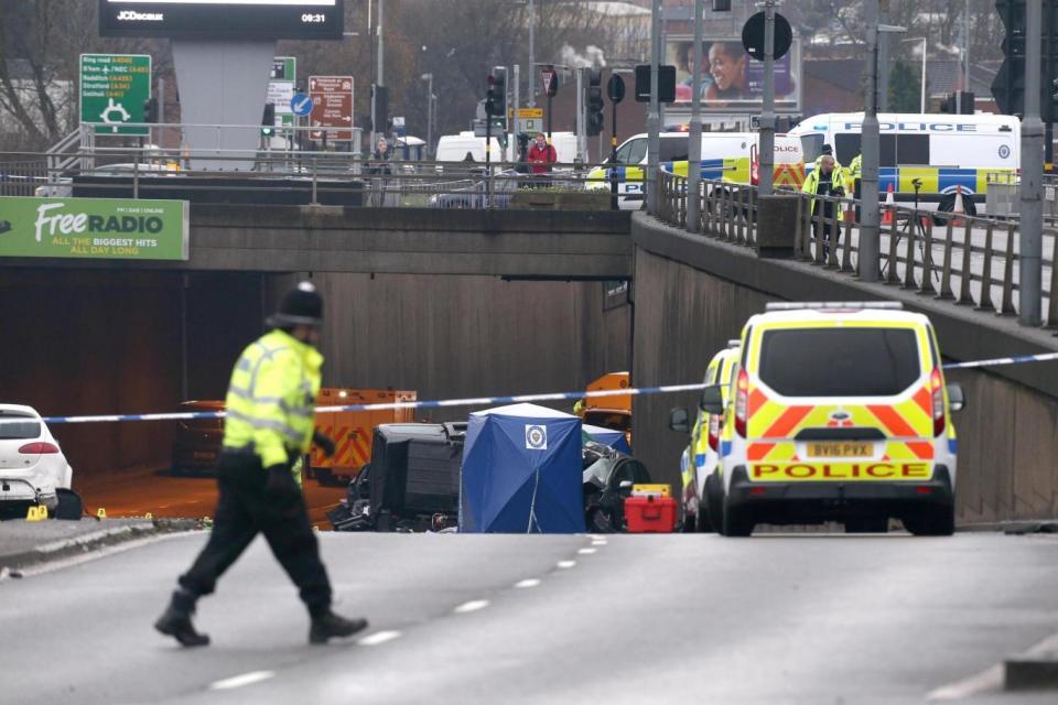 A police officers walks by the cordon and emergency vehicles at the scene of a multi-vehicle crash (PA)