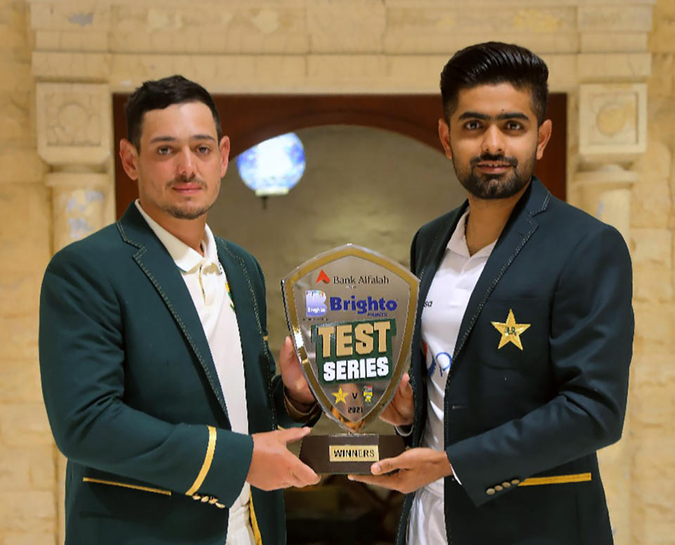 In this photo provided by Pakistan Cricket Board, Pakistan cricket team's skipper, Babar Azam, right, and his South Africa's counterpart Quinton de Kock pose for a photograph with the trophy of test-series, in Karachi, Pakistan, Monday, Jan. 25, 2021. Pakistan and South Africa will play the first test match on Jan. 26. (Pakistan Cricket Board via AP)