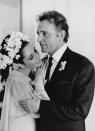 <p>Elizabeth wore a marigold, long sleeve dress and an elaborate white flowered hairpiece for her wedding to Richard Burton in Montreal, Canada. </p>