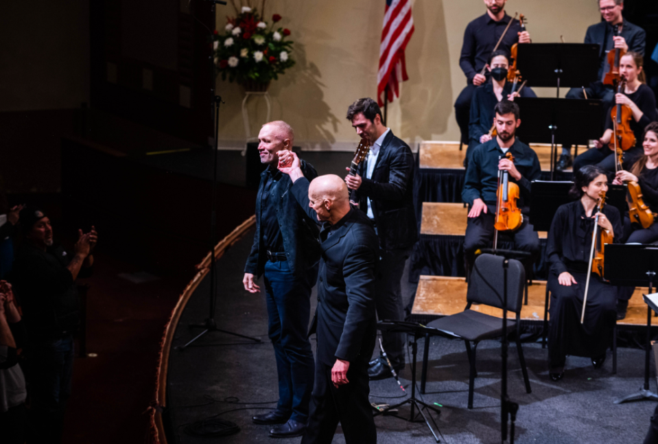 Composer Michael Abels, left, with conductor Mark Russell Smith and the QCSO in December 2022 for the premiere of his new guitar concerto, at Davenport’s Adler Theatre.