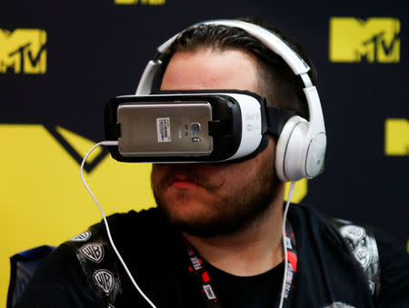 An attendee wears a virtual reality headset at Comic-Con International in San Diego, California, United States July 22, 2016. REUTERS/Mike Blake