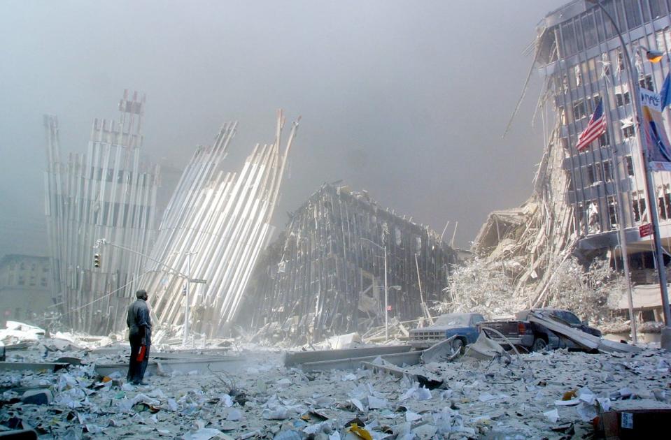 A man stands in the rubble, and calls out asking if anyone needs help, after the collapse of the first of the Twin Towers (AFP/Getty)