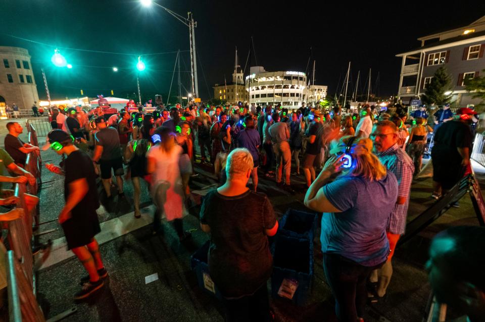 People wear different colored headphones at the Silent Disco held as part of Boat Night Friday, July 19, 2019, in downtown Port Huron.