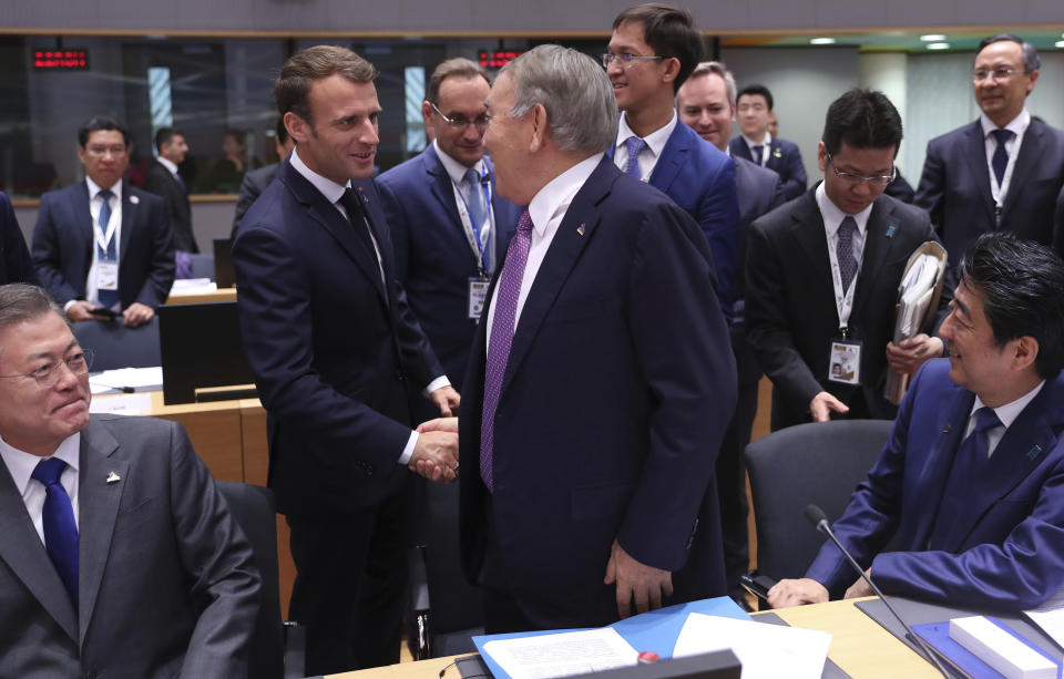 French President Emmanuel Macron, second left, shakes hands with Kazakhstan's President Nursultan Nazarbayev, center, during a round table meeting at an EU-ASEM summit in Brussels, Friday, Oct. 19, 2018. EU leaders meet with their Asian counterparts Friday to discuss trade, among other issues. (AP Photo/Francisco Seco)